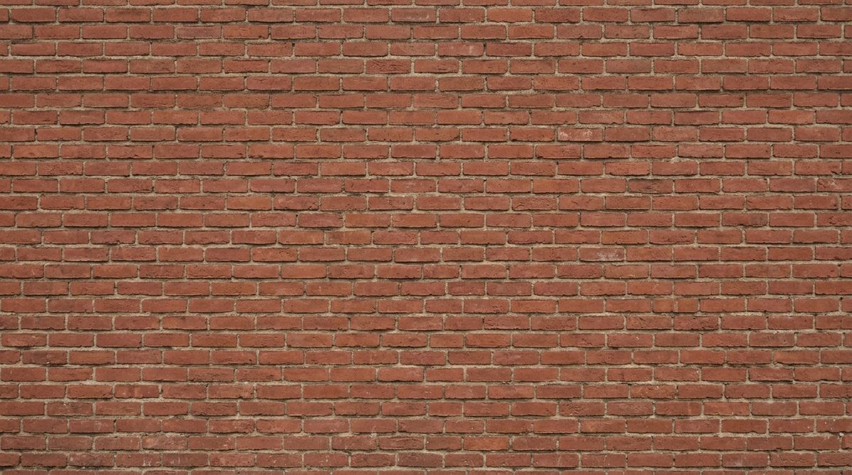 A plain red brick wall laid in running bond, the joints of each course sitting halfway along the bricks below